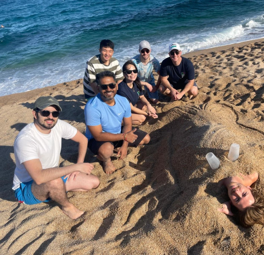 a group posing with their sand sculpture.