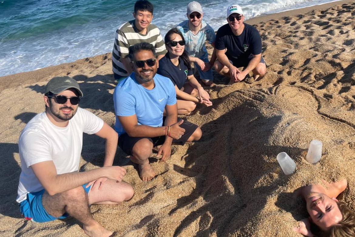 a group posing with their sand sculpture.